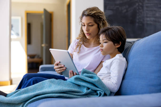 Mother and her sick son talking to the doctor on a video call - telemedicine concepts